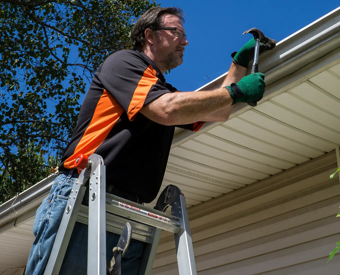 Worker Repairing A Gutter On A Customers Home in st louis mo