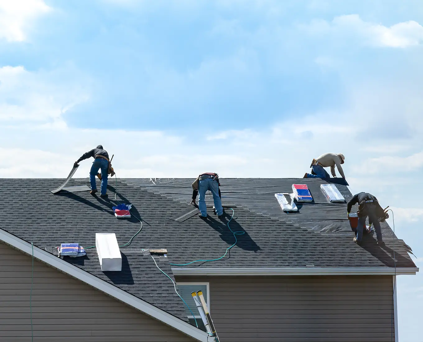 4 construction workers fixing roof and install shingles at the top of the house in st louis mo