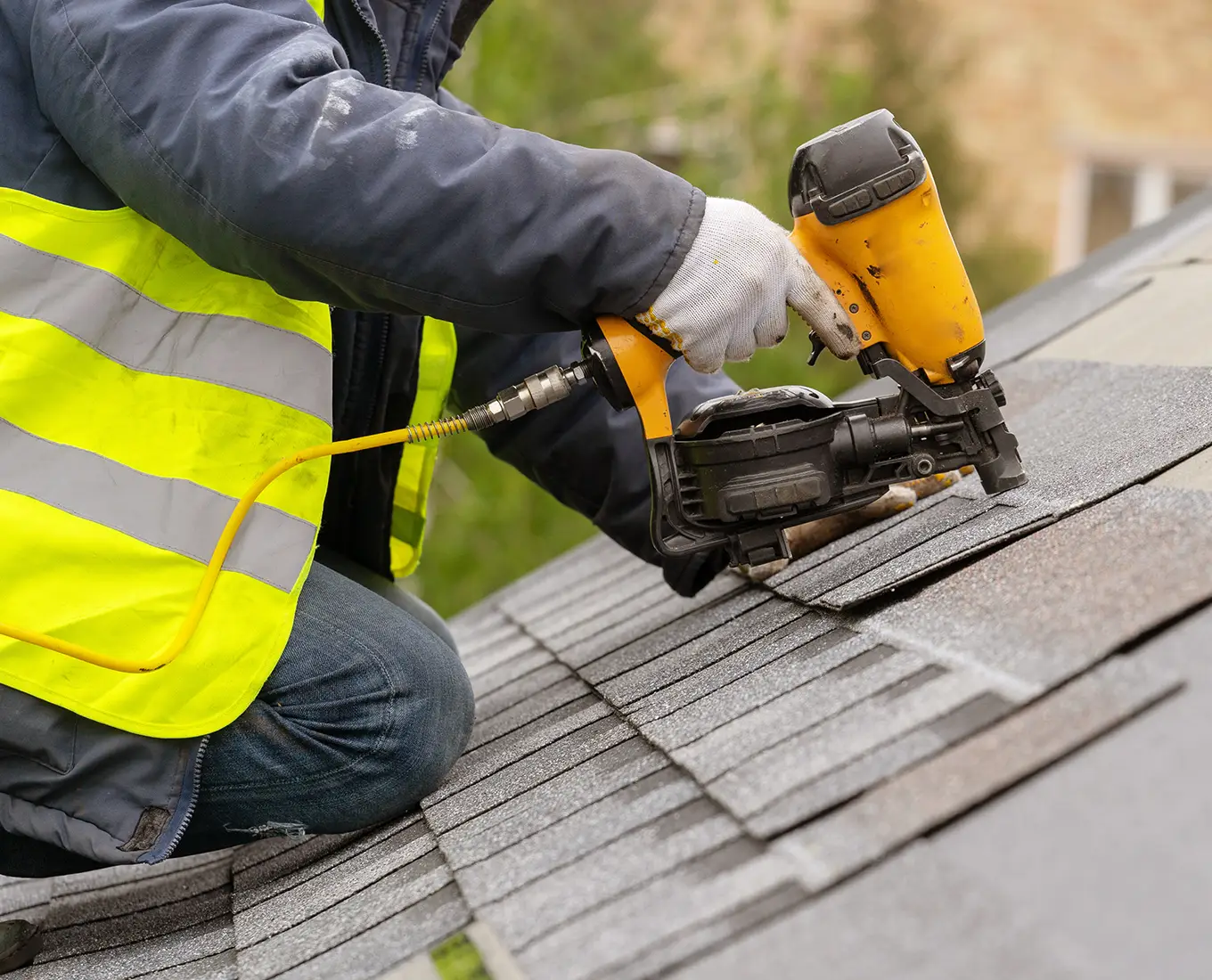 roofer installing new roof shingles on house roof in st louis mo