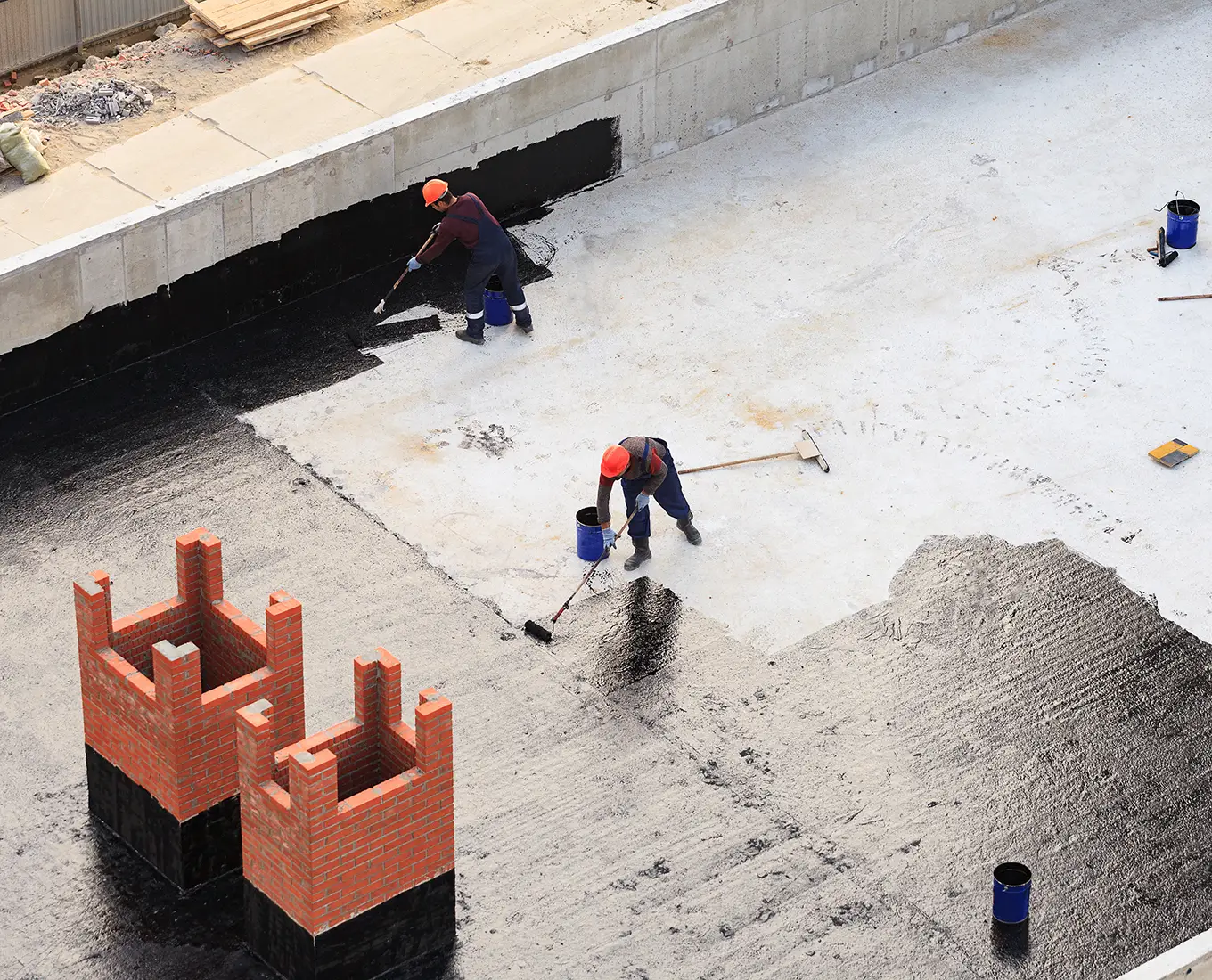 Two workers conduct waterproofing of the roof in st louis mo
