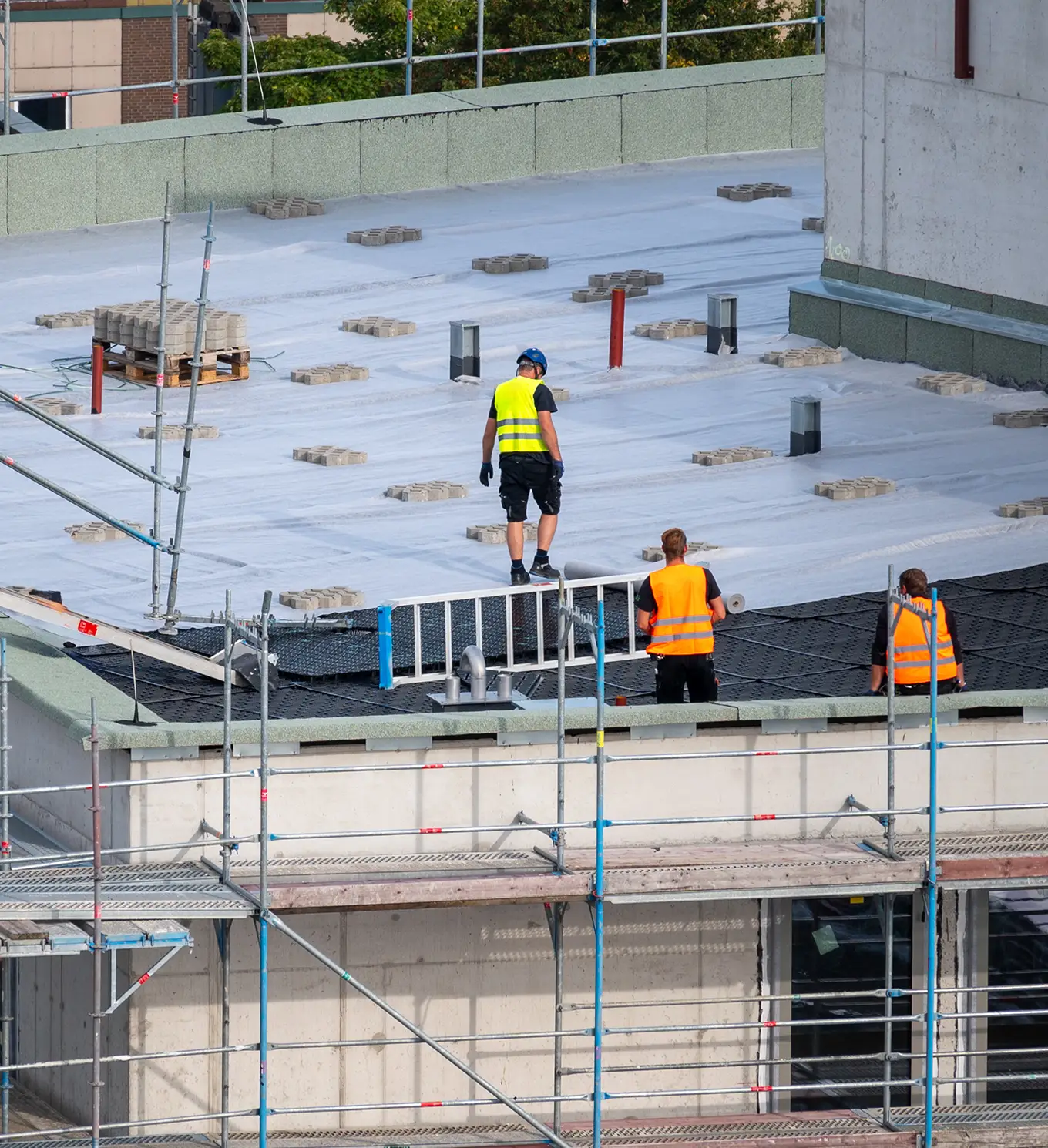 roofer waterproofing the flat roof of a commercial building in st louis mo