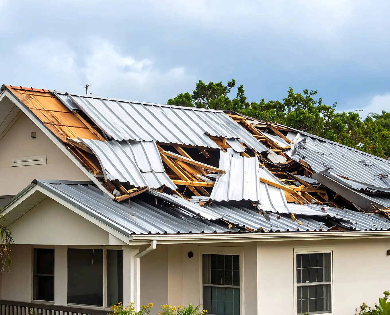 Storm-damaged house roof with exposed rafters and missing metal sheeting in st louis mo
