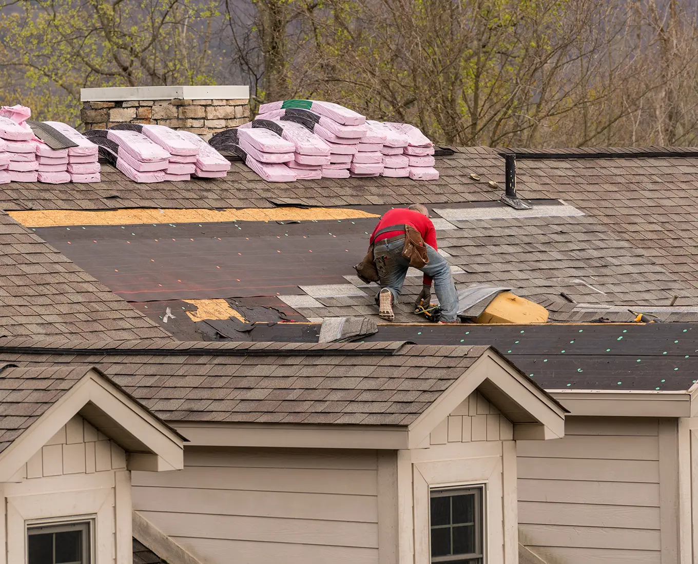 Roofing contractor removing the old tiles before replacing with new shingles on a townhouse roof in st louis mo