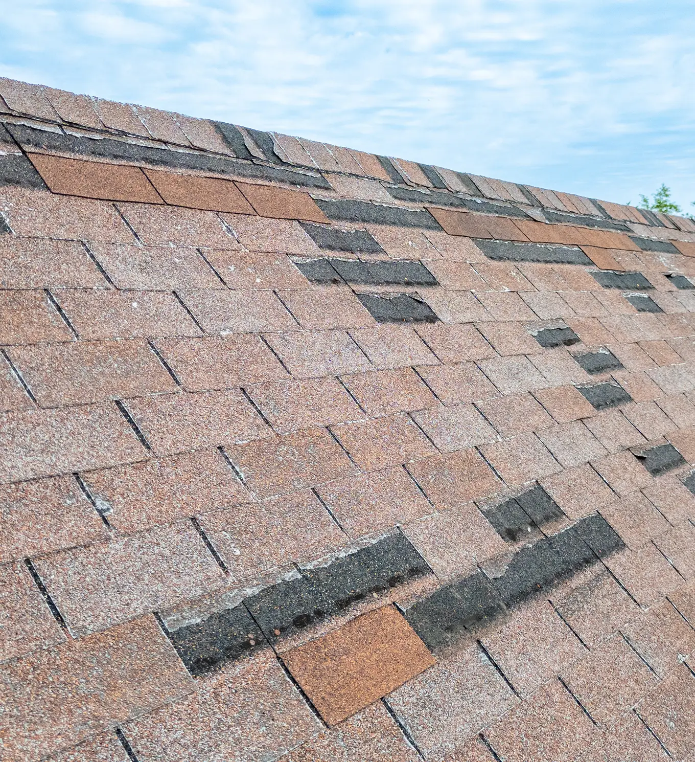 Roof with missing shingles from wind storm damage in st louis mo