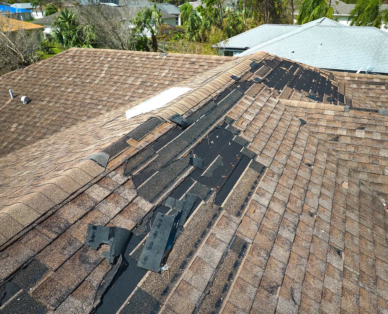 Damaged house roof with missing shingles after storm in st louis mo