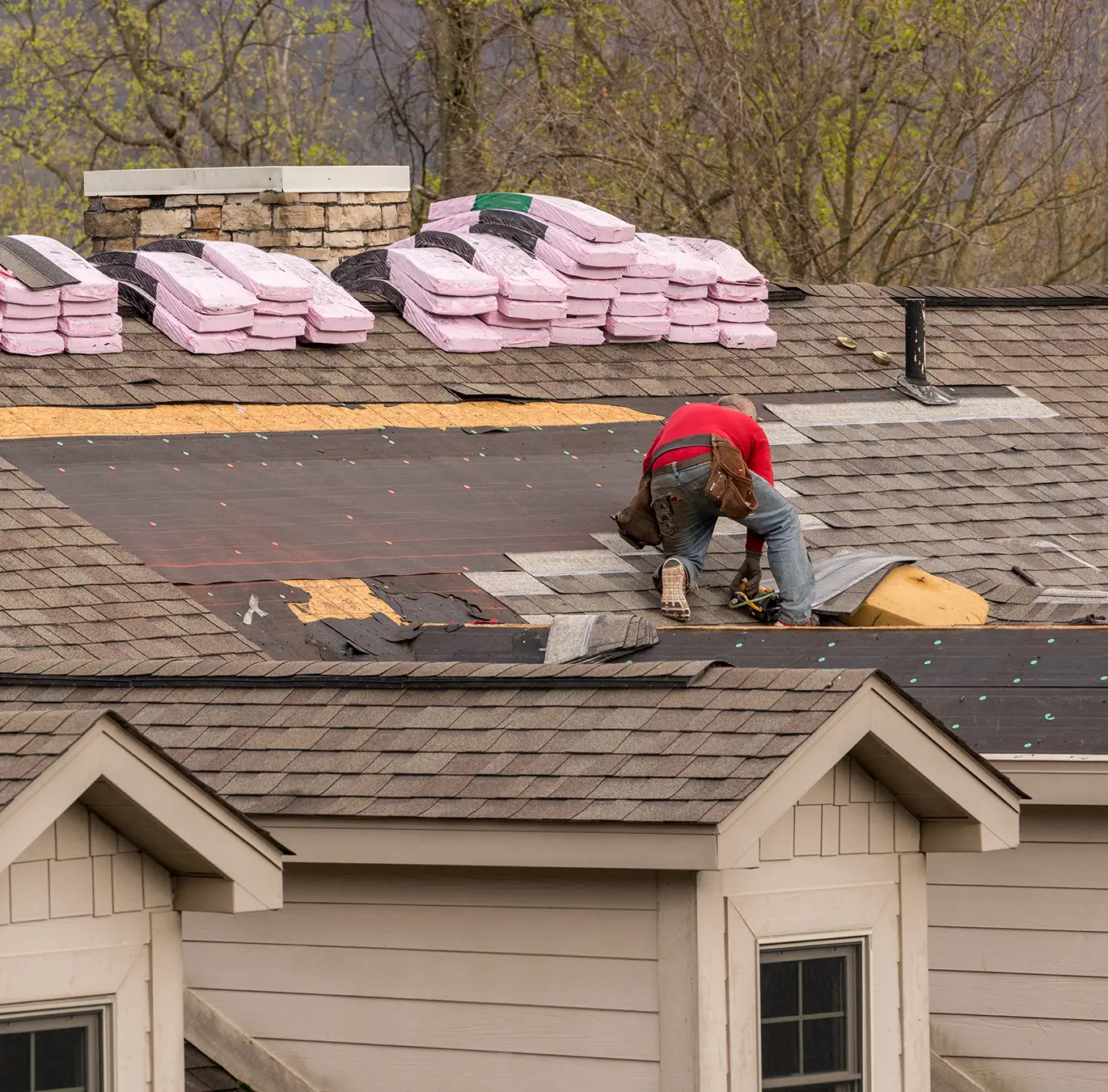 Roofing contractor removing the old tiles before replacing with new shingles on a townhouse roof in chesterfield mo