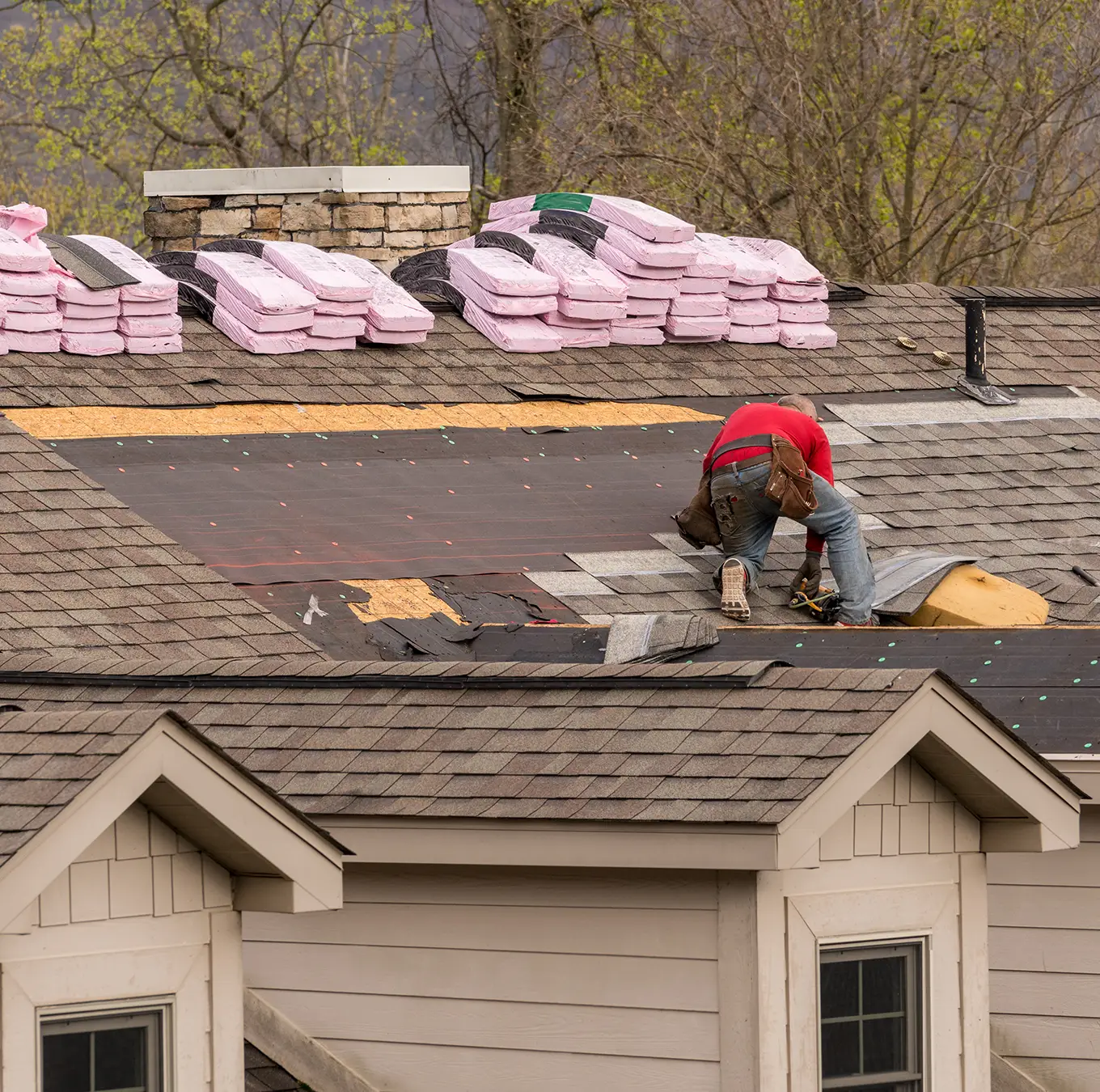 Roofing contractor removing the old tiles before replacing with new shingles on a townhouse roof in clayton mo