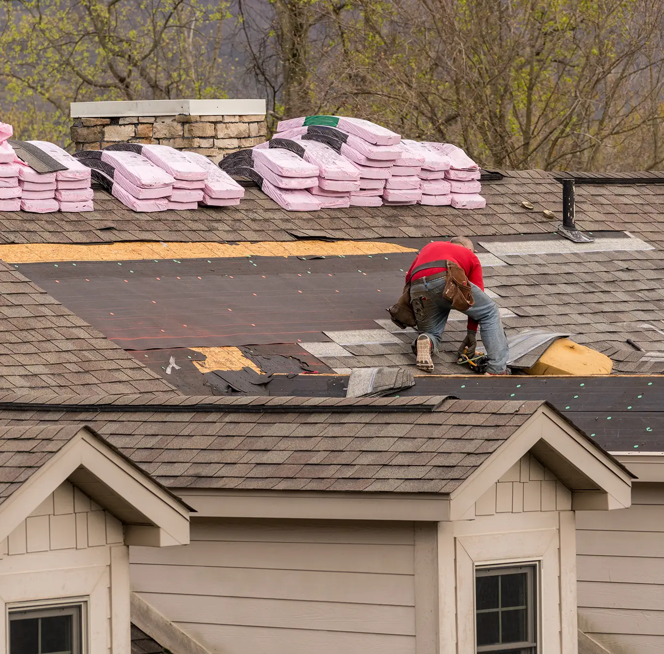 Roofing contractor removing the old tiles before replacing with new shingles on a townhouse roof in creve coeur mo