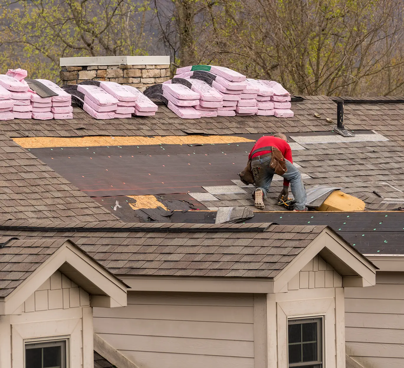Roofing contractor removing the old tiles before replacing with new shingles on a townhouse roof in kirkwood mo