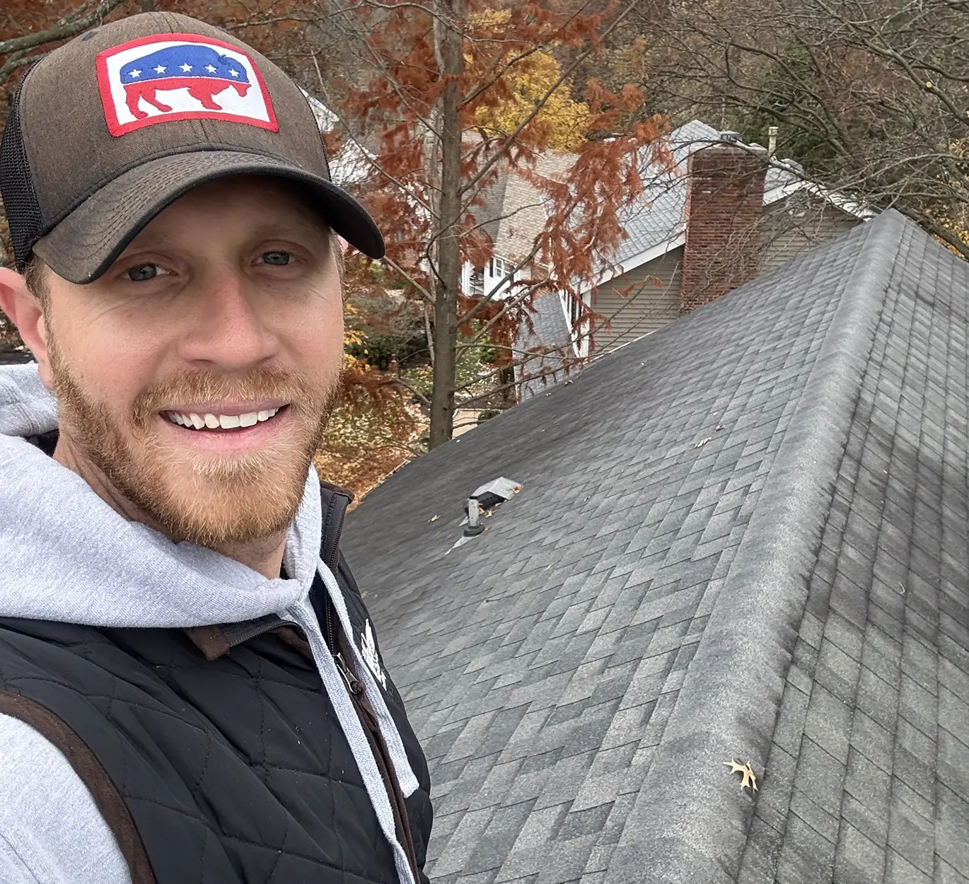 tanner on top of roof working on roof repair in ladue mo