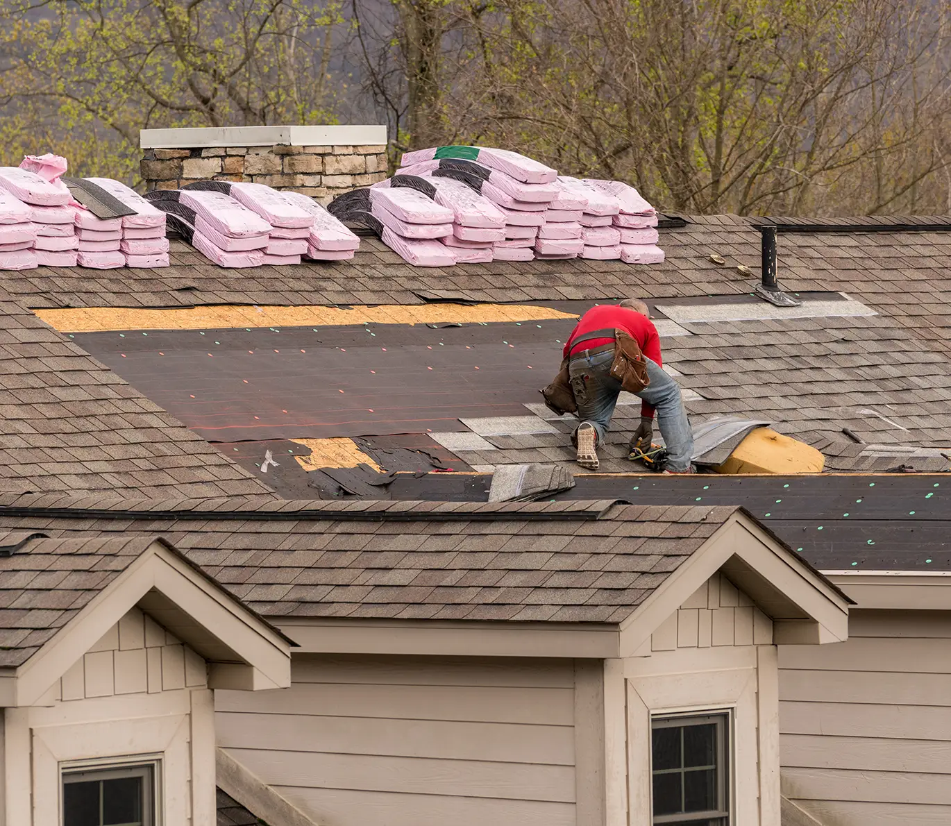 Roofing contractor removing the old tiles before replacing with new shingles on a townhouse roof in o'fallon mo
