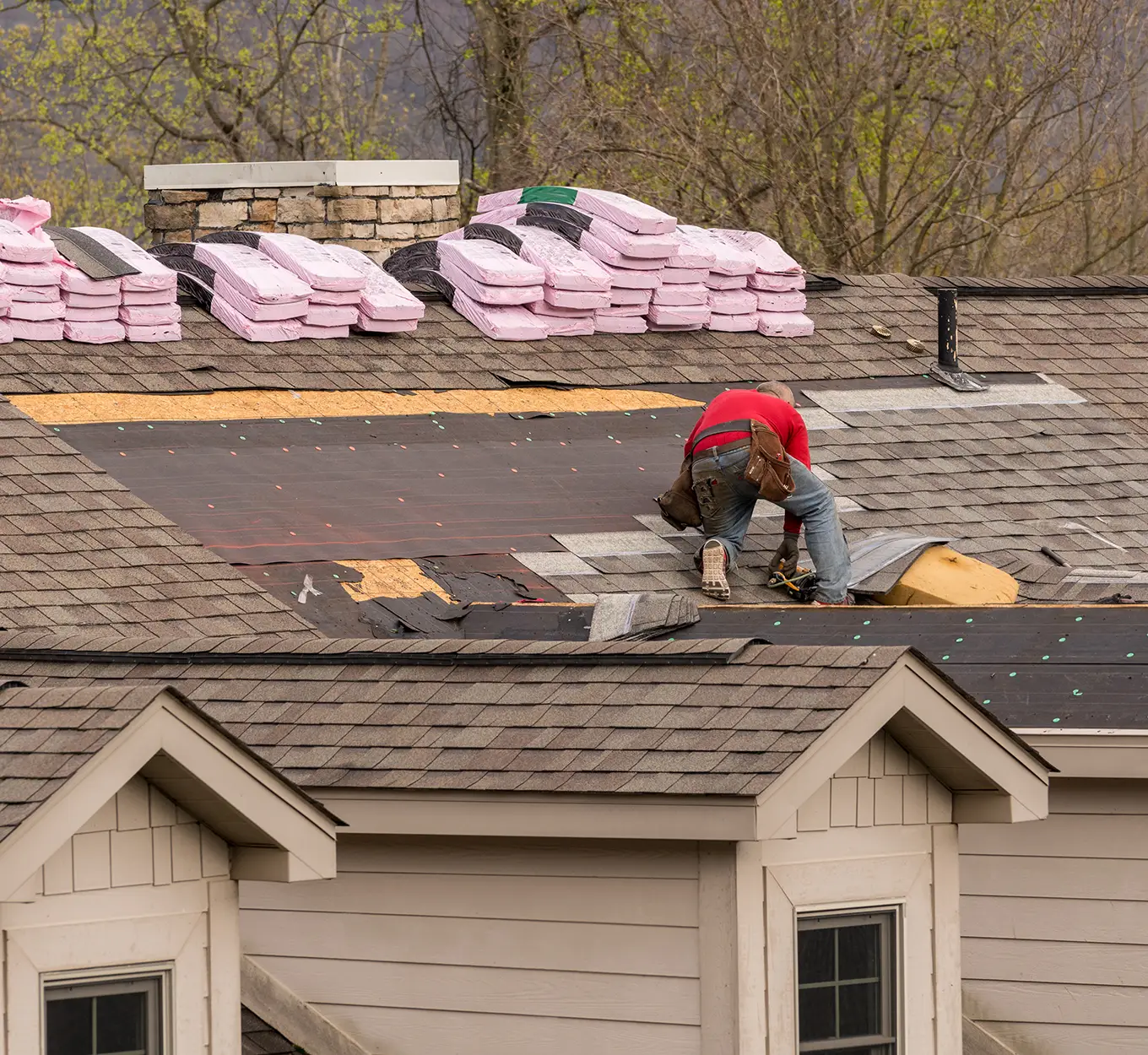 Roofing contractor removing the old tiles before replacing with new shingles on a townhouse roof in st louis mo